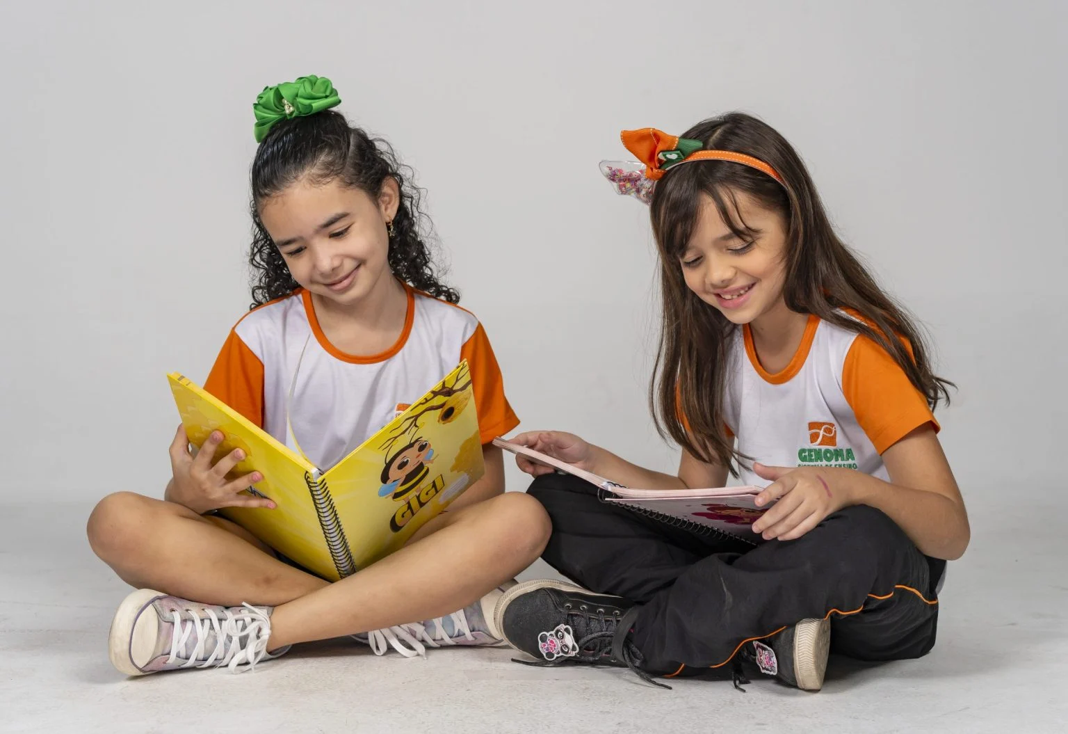 Material Escolar 2026 6 Duas alunas do Genoma lendo livros didáticos